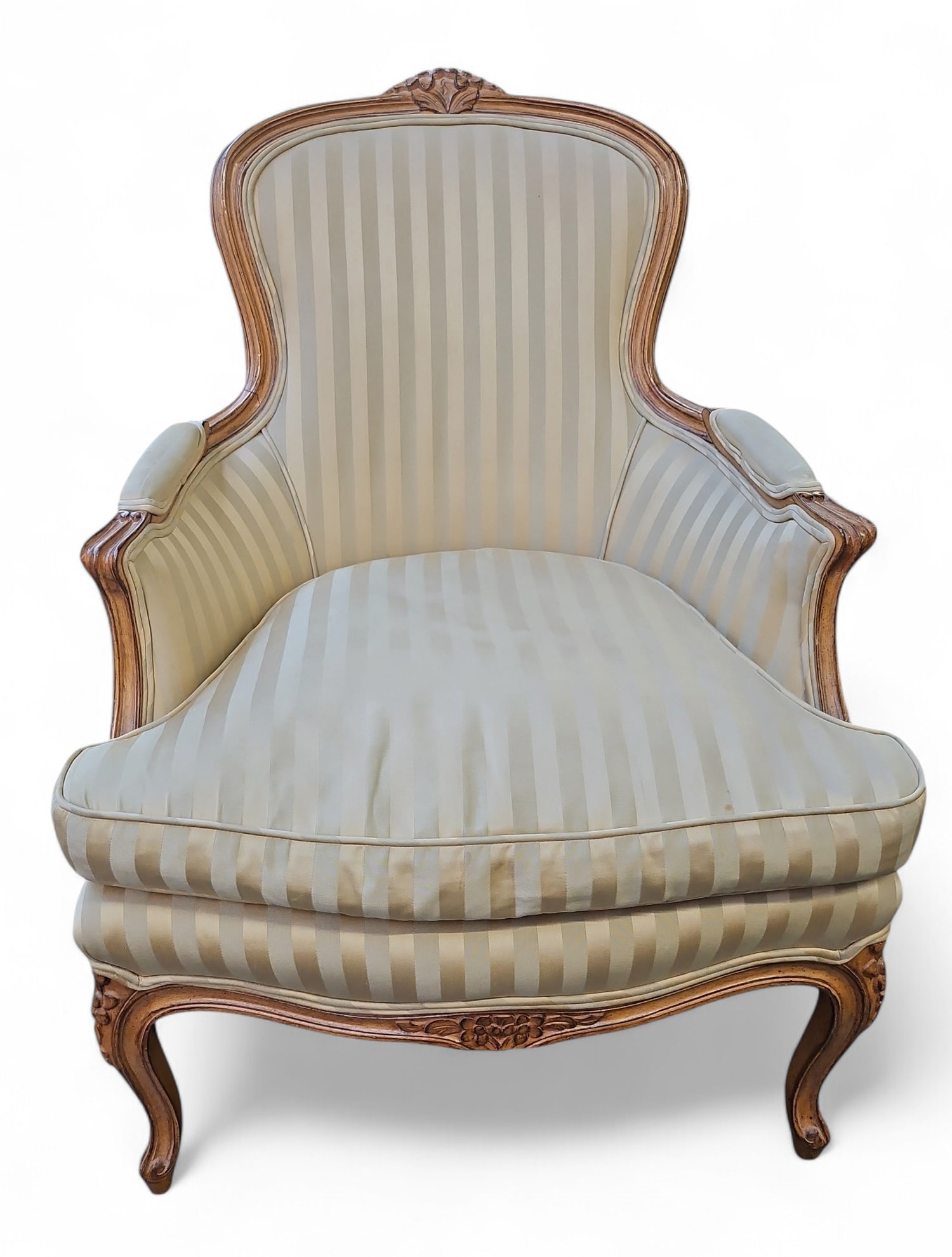 French Louis XV Style Bergere Carved Armchair.: This piece features hand carved designs on the wood, and beige striped upholstery. The chair measures 36 3/4" tall, 25 1/2" wide, and 23 1/2" deep. The fabric has some stains, and the wood has some sc