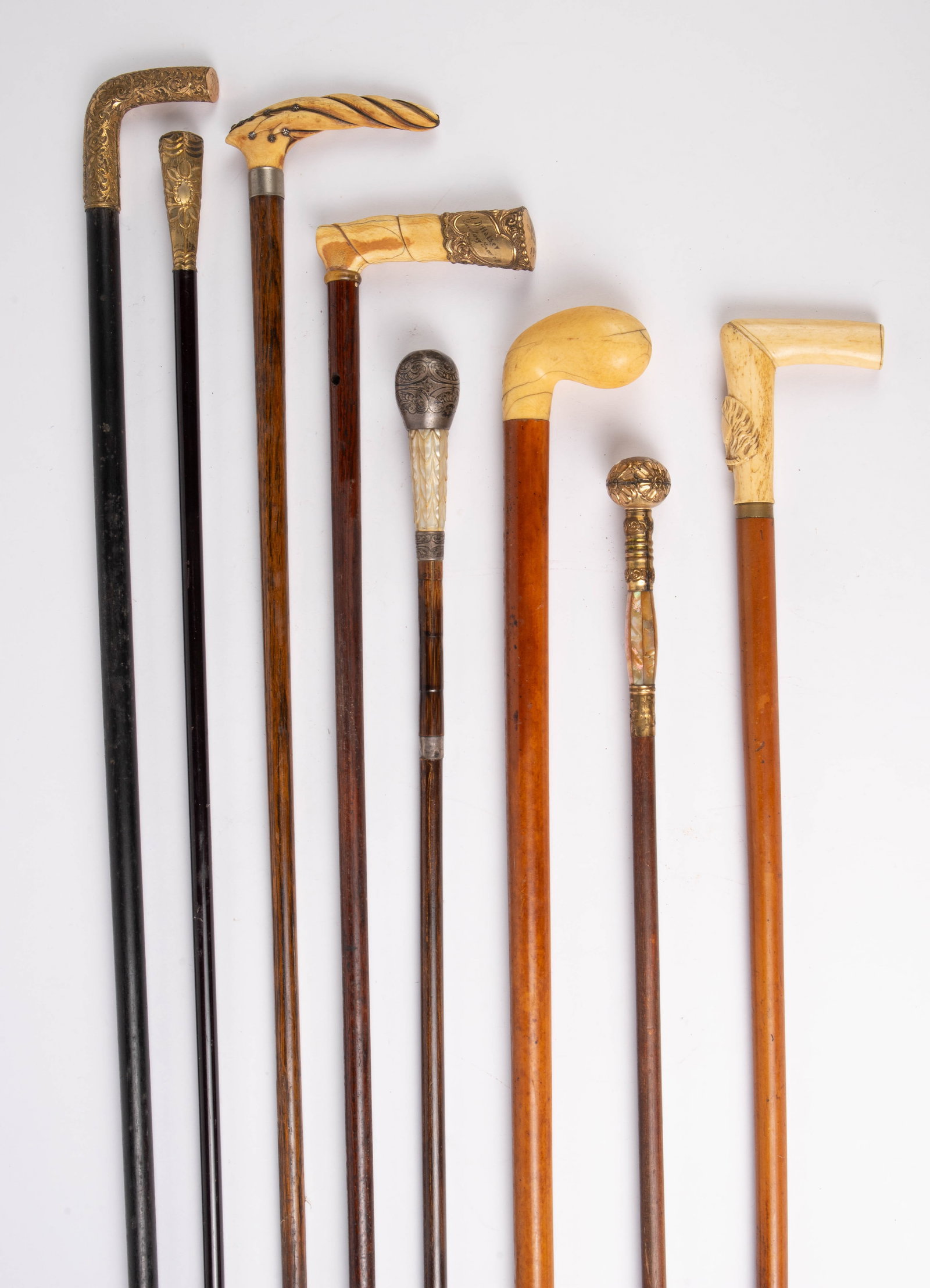 Lot of 8 Vintage & Antique Canes w/ Unique Handles: These wood canes and walking sticks all have interesting handles, some of them quite ornate. One of them is made up of both sterling silver and mother of pearl. Another is brass and mother of pearl. T
