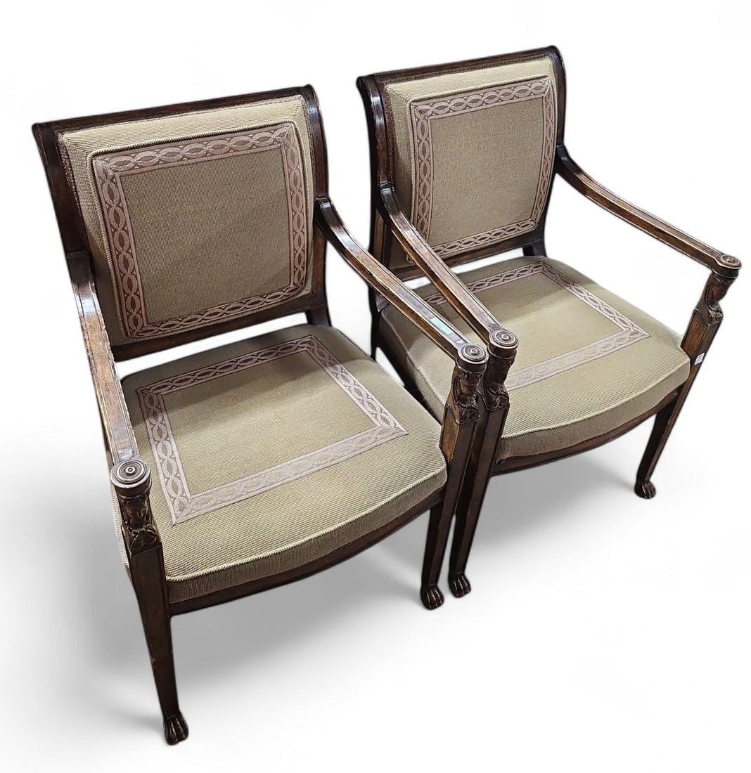 Pair of French Empire Style Armchairs.: This pair of French empire style armchairs are upholstered, and have carved Egyptian bust decorations and claw feet. The chairs have a light and dark wood frame. They measure 36" tall, 23 1/2" wide, a