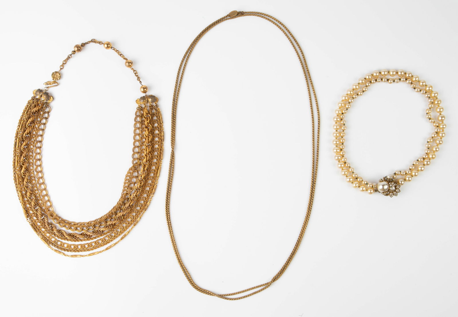 Vintage Necklaces - Robert DeMario, Miriam Haskell: The lot consists of 3 necklaces. First, there is an adjustable 7 strand gold tone chunky necklace, signed DeMario on the clasp. Next, there is a 2 strand faux pearl necklace with an elaborate clasp. I