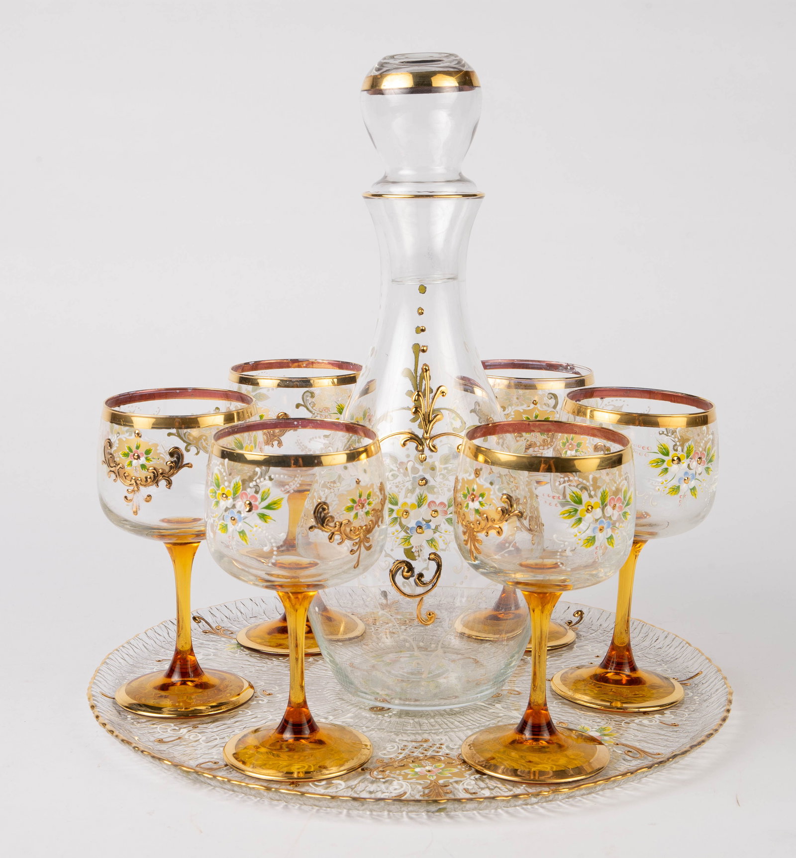 French Decanter and Goblet Set w/ Enameled Flowers: The set is Bohemian style; the bottoms of the goblets are stamped, "France". The decanter, glasses, and tray are all decorated with enameled flowers, and look to be in very good condition. The decante