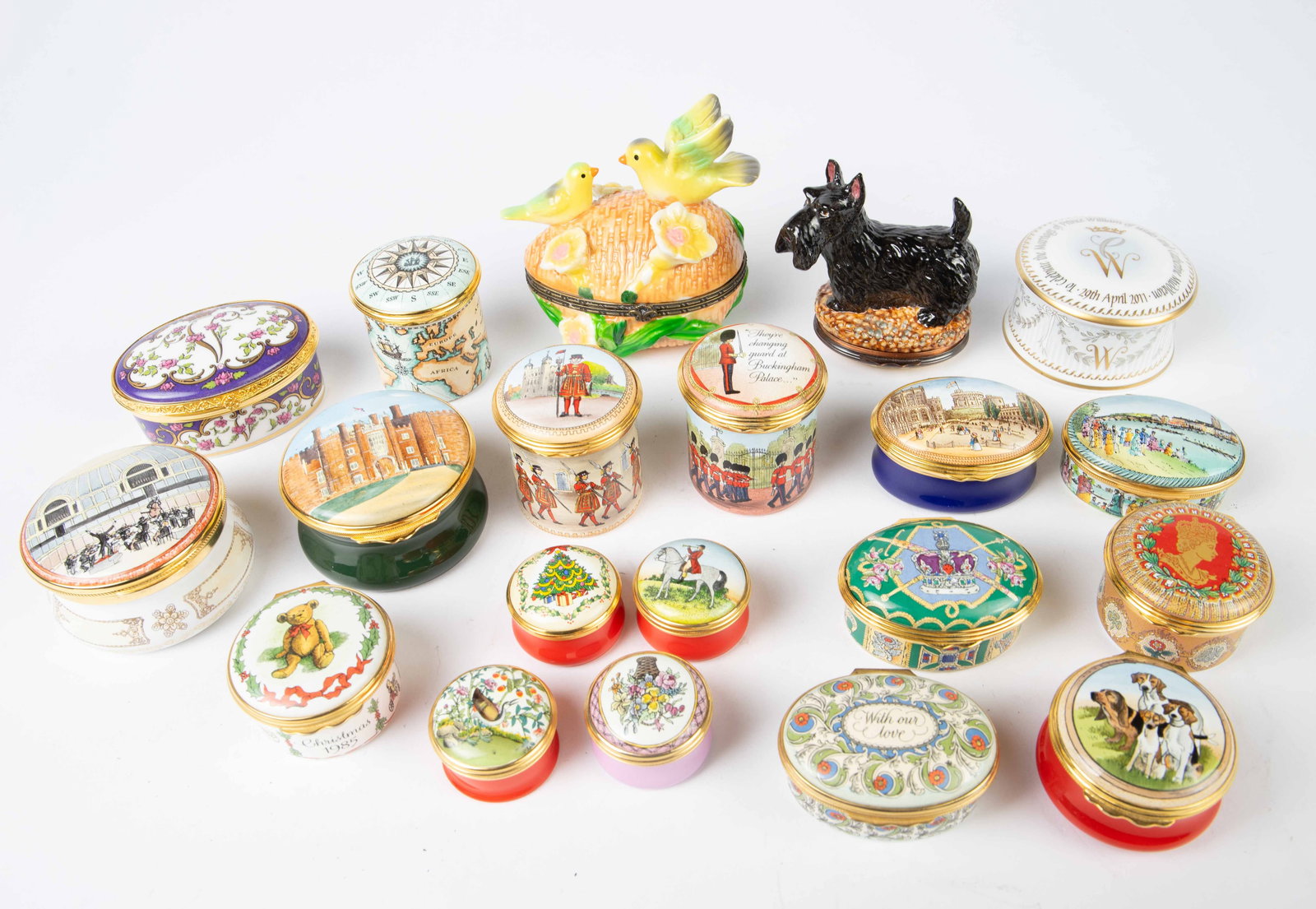 Lot of Pillboxes, Mostly Halcyon Days Enamels.: There are 20 pillboxes total, 14 of which are made by Halcyon Days Enamels. The themes include Christmas, Buckingham Palace, and animals, among others. The remaining six pillboxes include McLaughlin G