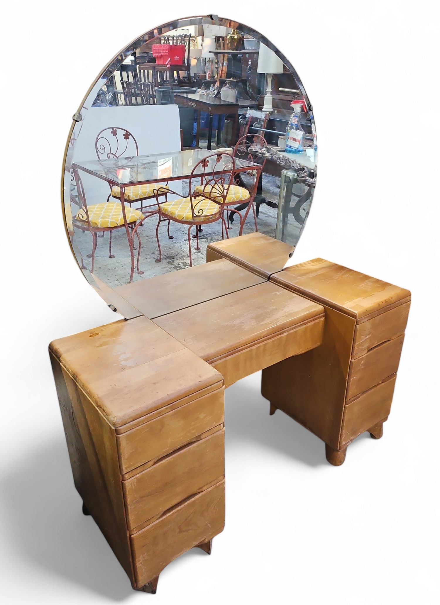Art Deco Style Vanity with Mirror.: This birch vanity features seven drawers and a circular bevelled mirror. It shows a lot of surface wear. The top of the left side has a crack, and the feet on the left side has cosmetic damage. Though