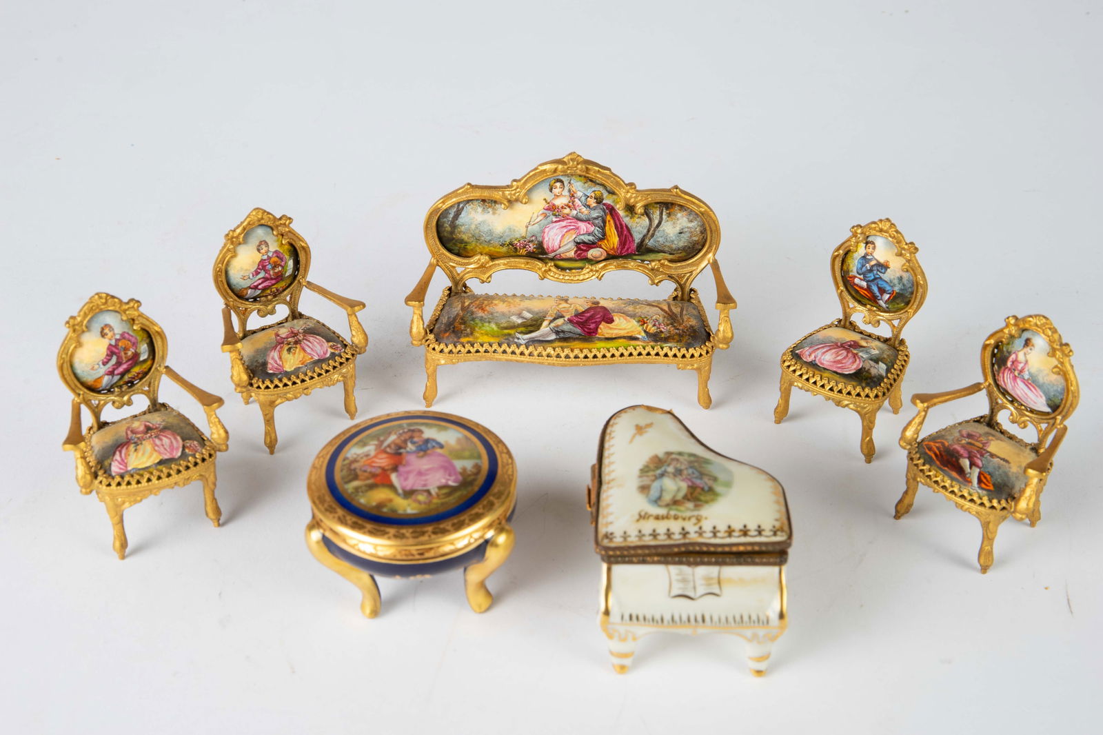 Gilt Bronze Hand Painted Miniature Furniture Set.: The 5-piece elaborate gilded furniture set consists of a settee sofa and four matching chairs. They have enameled backs and seats, displaying leisure scenes of young men and women. Also included in th