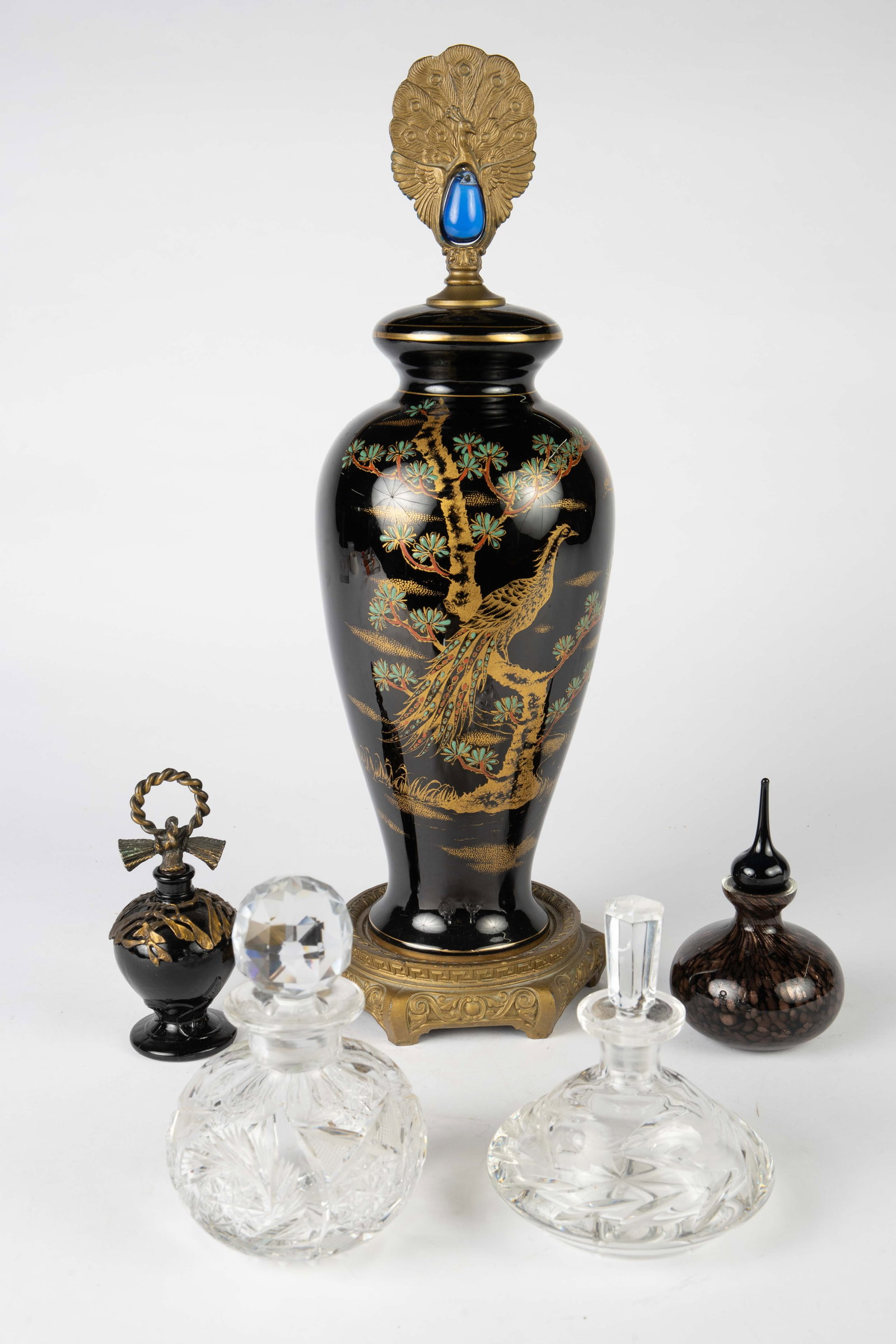 Lot: Peacock Garniture, 4 Perfume Bottles.: The Asian style peacock garniture was likely a lamp at some point. It resembles a Chinese scene, but may be Czech. It has a bronzelike peacock finial with a blue jelly belly, and an attached bronzelik