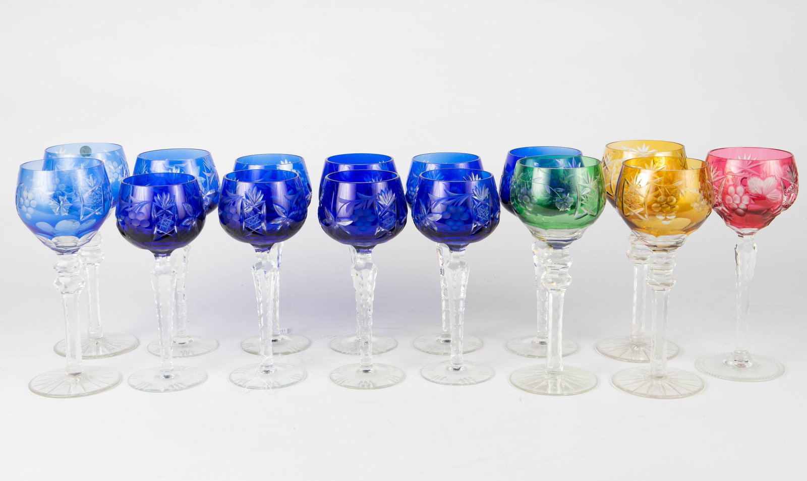 Lot of 15 Cut to Clear Rhine Wine Glasses.: Seven of them are a set of cobalt blue glasses; two others are similar to these, but larger. The remaining six are amber yellow, emerald green, cranberry pink, and a lighter shade of blue. Three of th