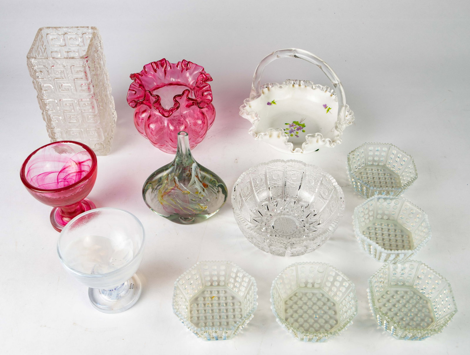 Lot of Asst. Glass, inc. Fenton & Kosta Boda.: This lot includes a pair of Kosta Boda footed dessert bowls by Ulrica Hydman-Vallien, a signed George Fenton ruffled basket, a Michael Harris lollipop vase, a set of 5 octagonal hobnail berry bowls (s