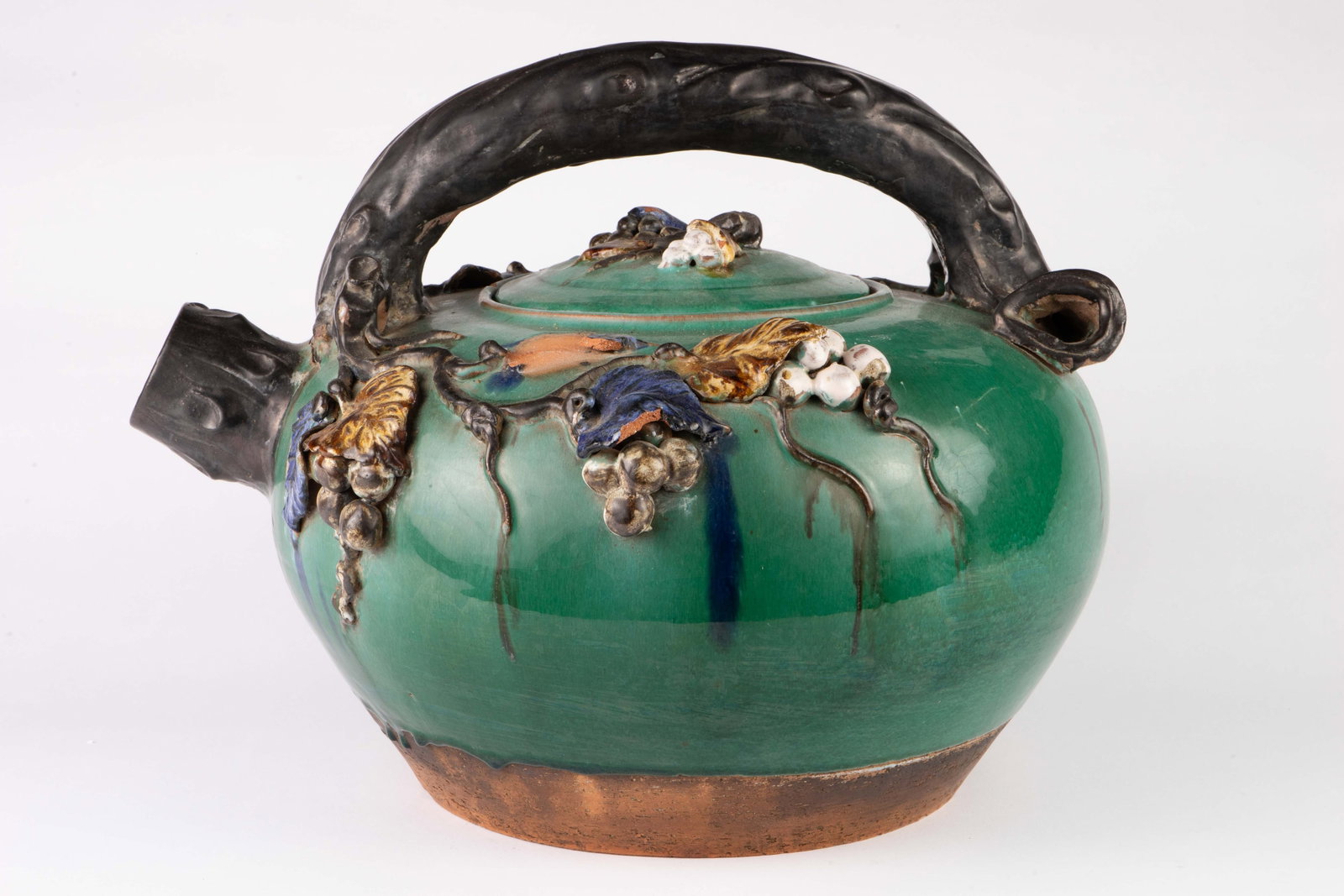 Large Sumida Gawa Japanese Art Pottery Teapot.: This oversized lidded teapot features leaf and fruit decorations. It measures 14" tall, 18" wide, and 16" deep. The piece is fragile, and there are some cracks, chips, and stains on the piece. See pho