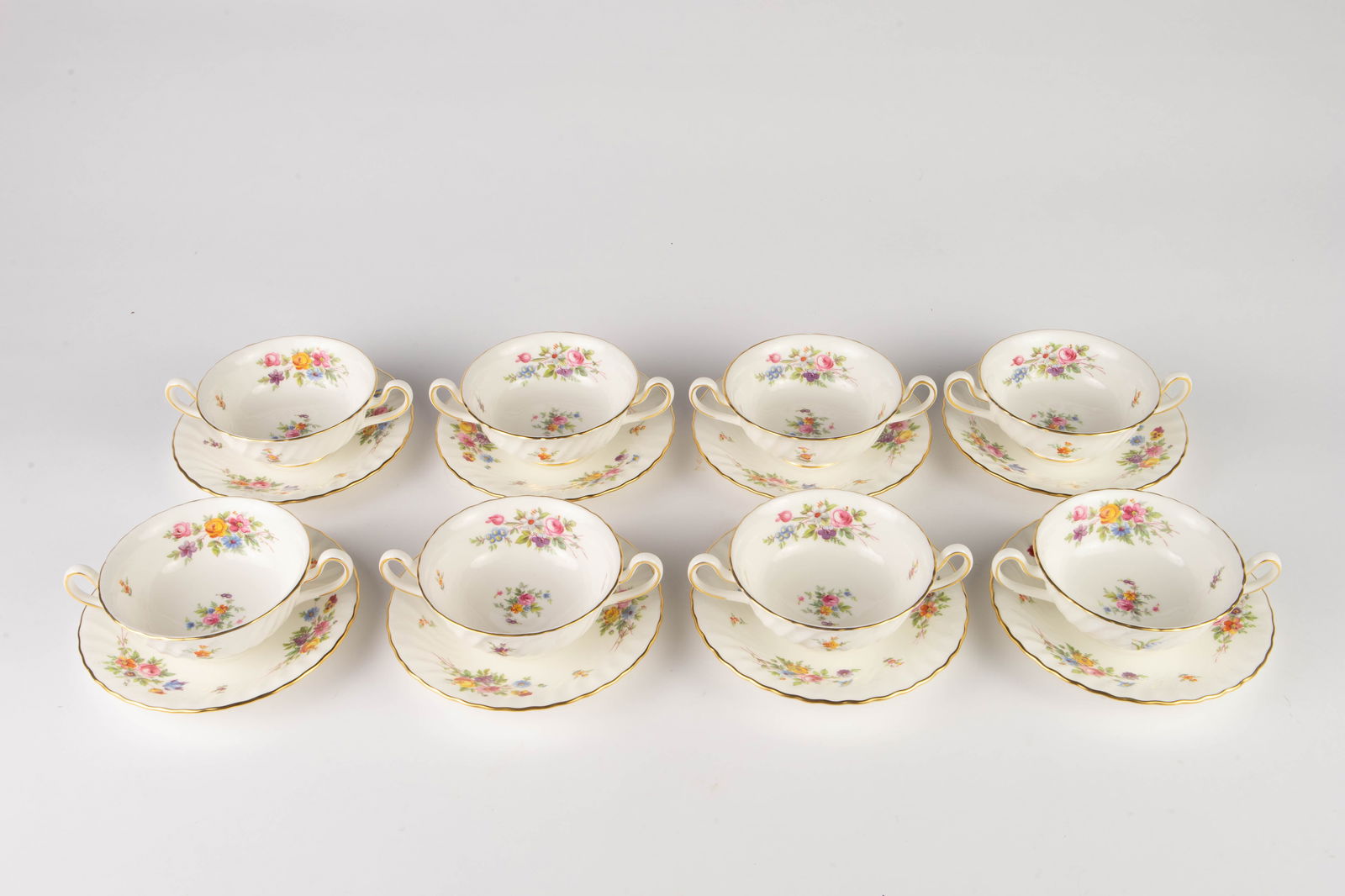 Minton Marlow Set of 8 Cream Soup Bowls w/ Saucers: They are two-handled soup bowls with matching saucers, decorated with brightly colored flowers. Overall, the lot looks to be in good condition. The bowls measure 6 1/2" across, from handle to handle.