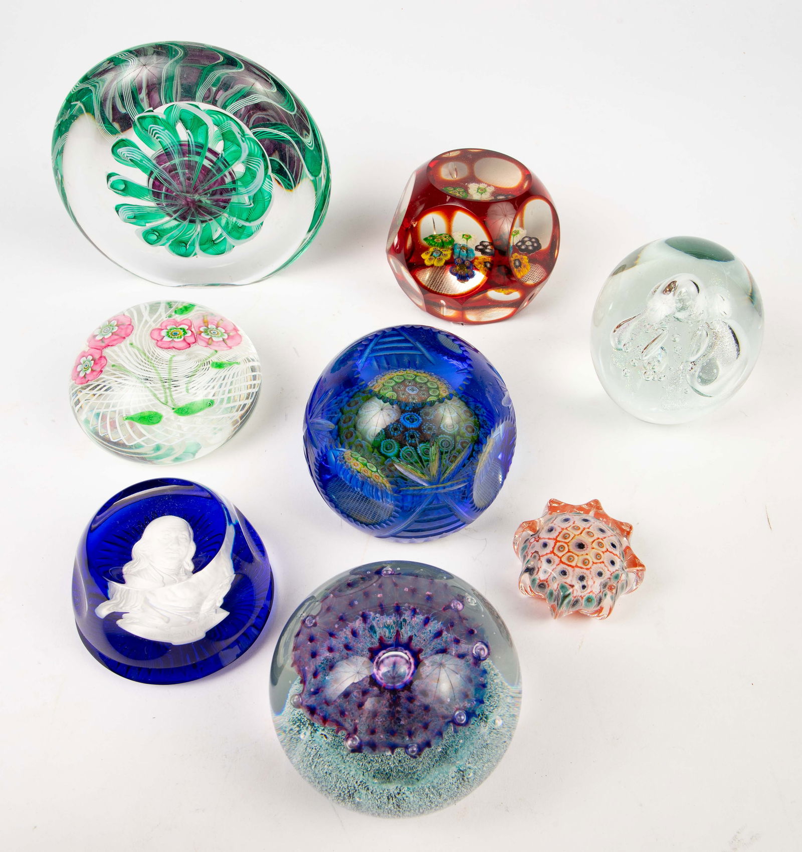 Lot of Art Glass Paperweights, incl. Eickholt.: This lot includes a large paperweight signed, "OKL Studio '96", a signed Eickholt paperweight, a Franklin Mint paperweight with a portrait of Benjamin Franklin, a Caithness paperweight, two faceted pa