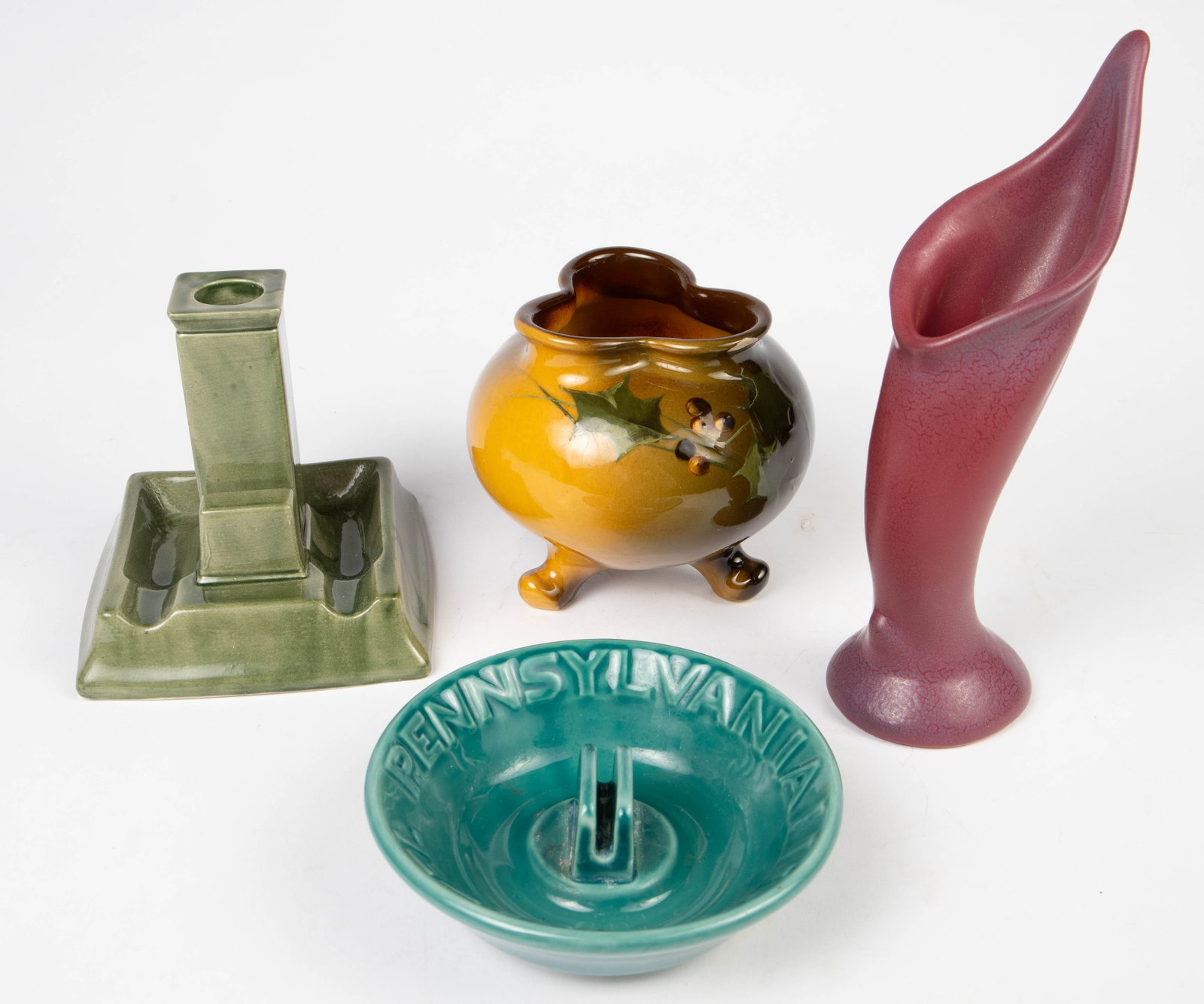 Lot of Pottery, inc. Van Briggle, Louwelsa Weller: The lot includes a Louwelsa Weller 3-legged vase (chip on the rim), a Van Briggle 8 1/2" mulberry bud vase, a Hotel Pennsylvania ashtray, and a Lamberton "The Stevens" ashtray. Overall, the lot looks 