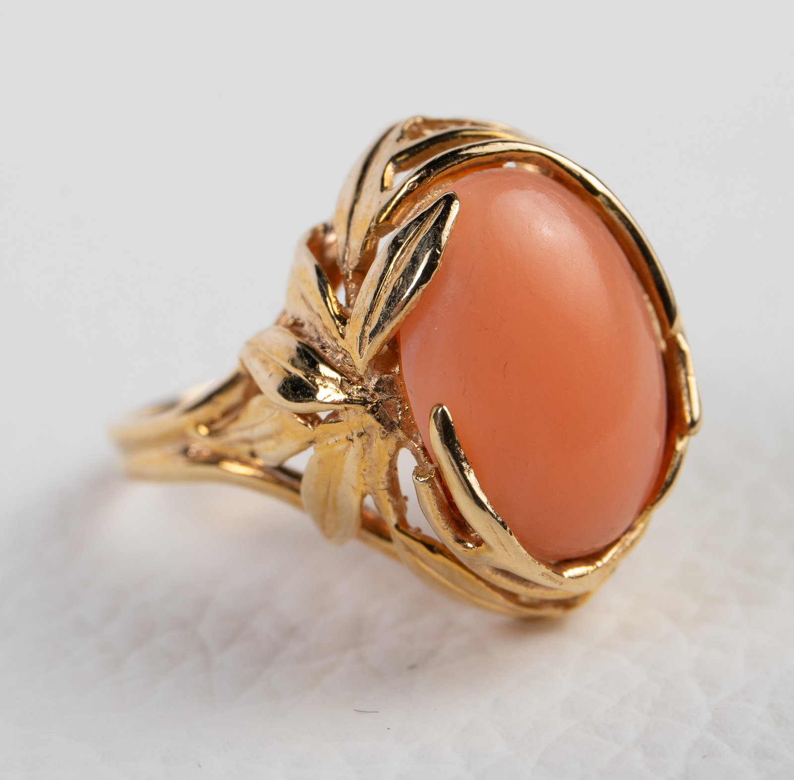 14K Gold Pink Coral Ladies' Vintage Ring.: This ring is marked 14K inside the band. It features a large 14mm x 9mm cabochon pink coral stone, surrounded by leaf designs. It is a size 7 and measures up to 3/4" wide. It weighs 3.3 Pennyweight, o
