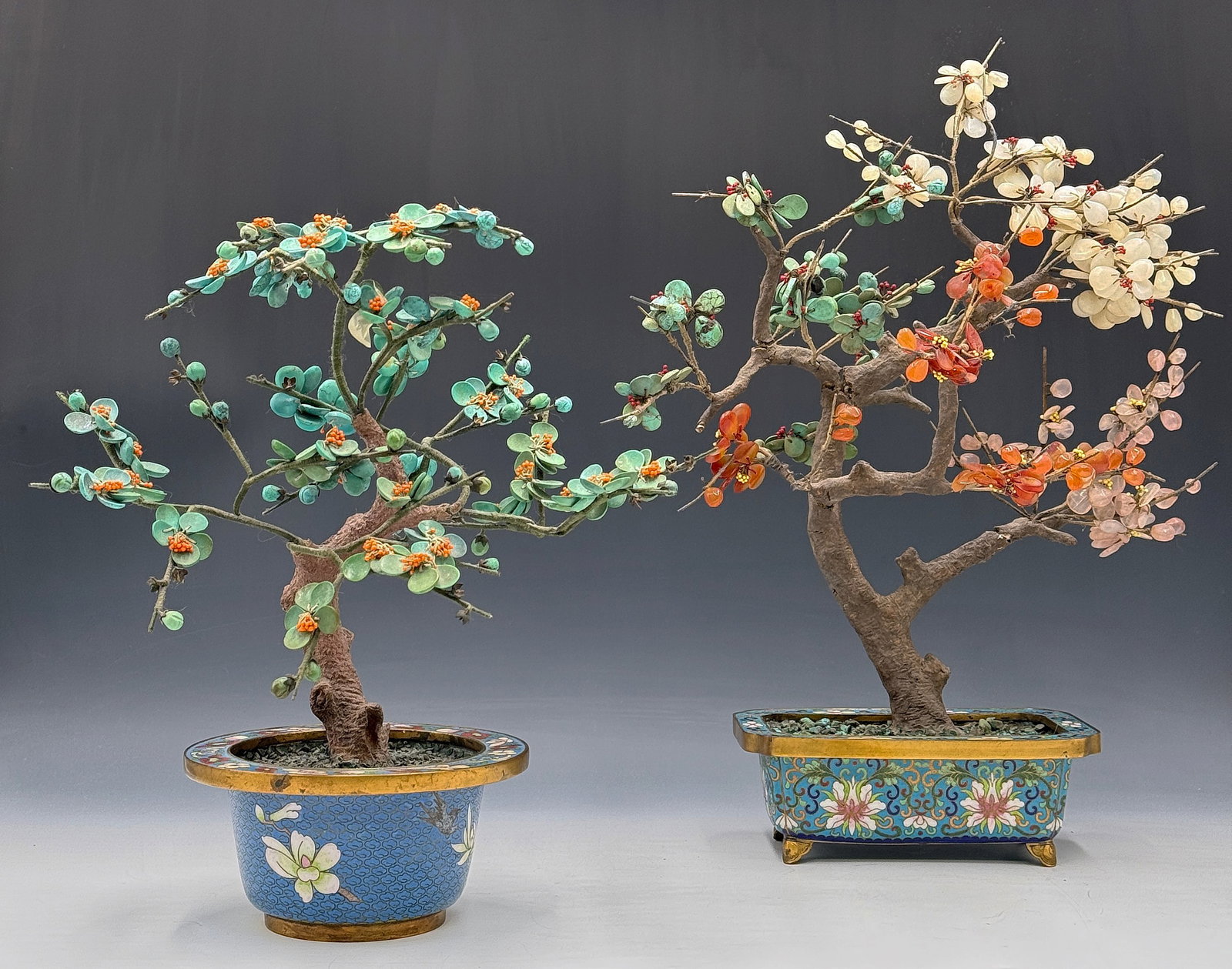 Lot of 2 Chinese Cloisonne Mineral Trees.: The trees have jade, agate, turquoise and rose quartz stones. There may be some missing elements to each tree. The larger of the two trees measures 16" tall, 12" wide, and 7" deep. Third-party shippin