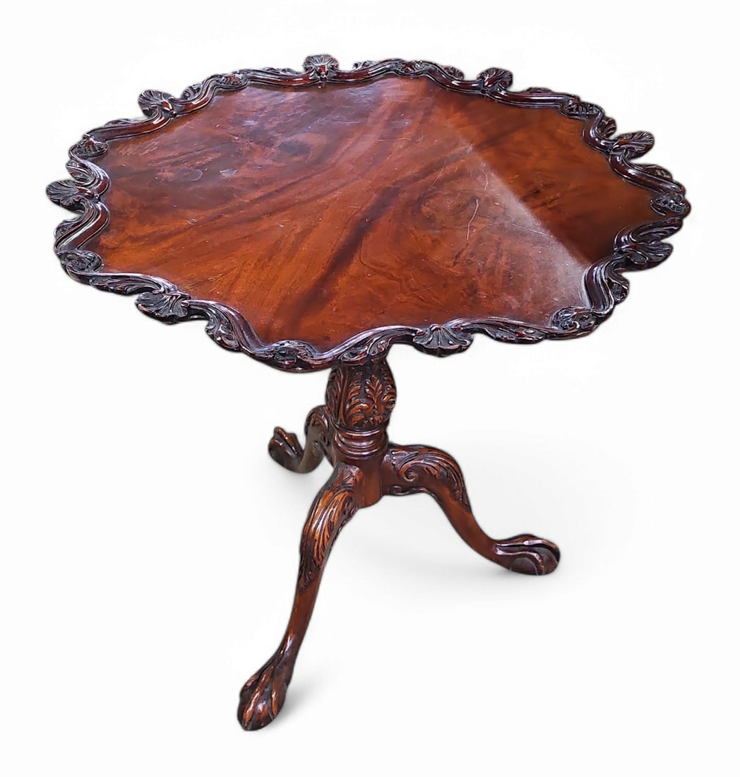 Carved Mahogany Chippendale Style Lamp Table.: This carved flame mahogany Chippendale style lamp table has carved wood ball and claw feet. It measures 30" tall and 31" in diameter. There are some scratches on the piece. Otherwise, it is in overall