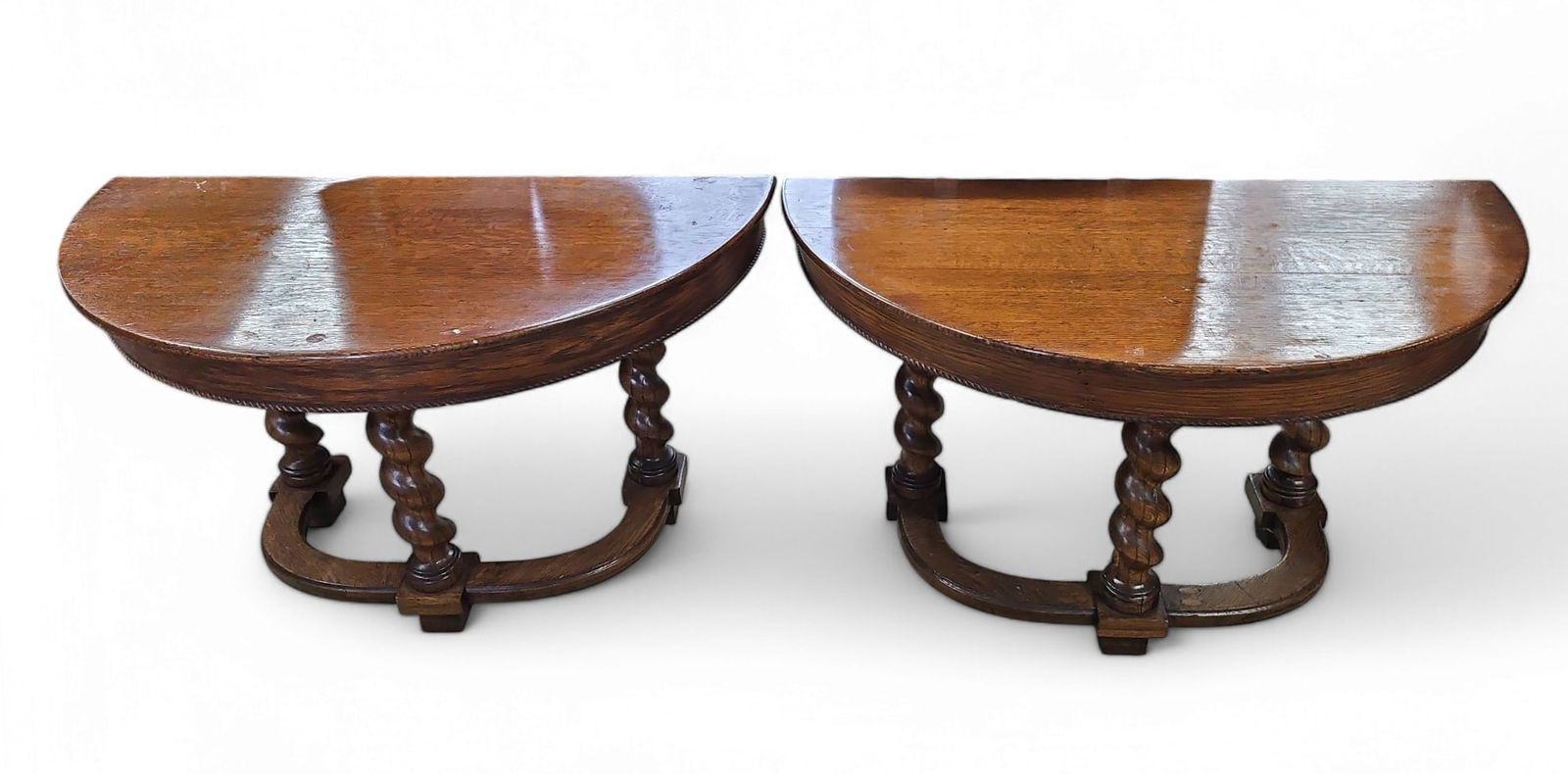 Pair of Antique Jacobean Demilune Tables.: These oak Jacobean demilune tables have barley twist legs. The tables can function as two hall tables, or join together to form a dining table. There are some scratches and indentations, but overall,