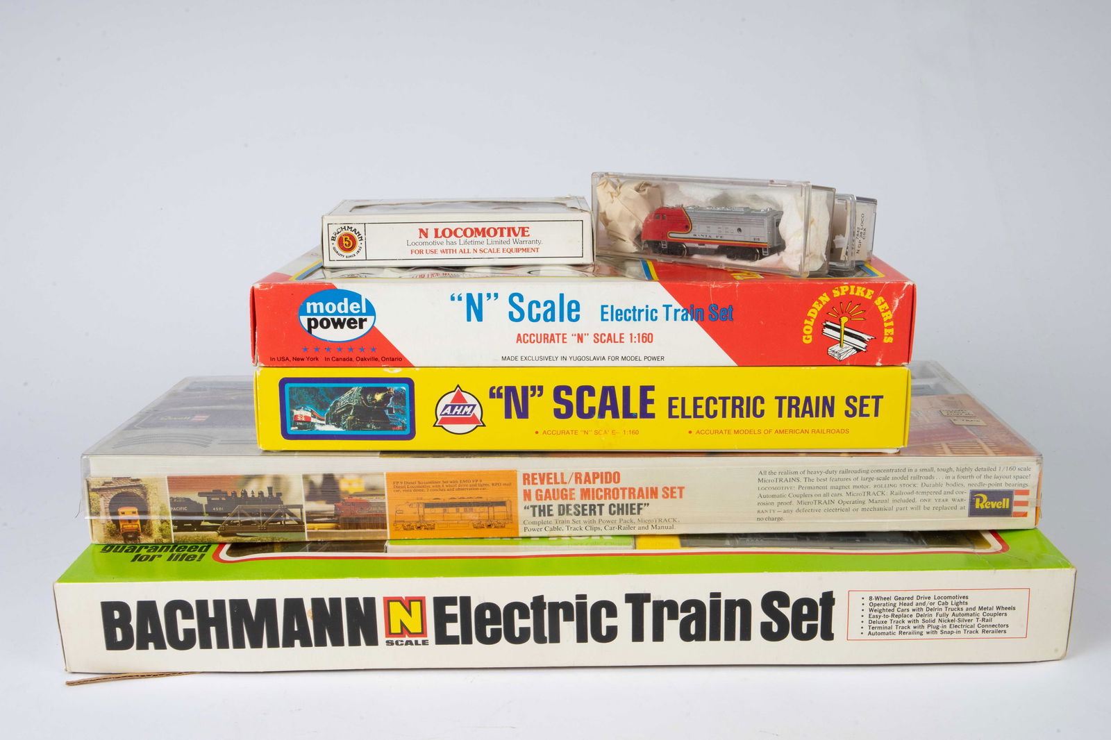 Lot N Gauge Train Sets - Bachmann, A.H.M, Revell.: The lot contains four N scale train sets and 3 independent cars. The sets are Brachmann "Spirit of 76" No. 4370, Revell "The Desert Chief" microtrain set No. 2085, Model Power Golden Spike Series elec