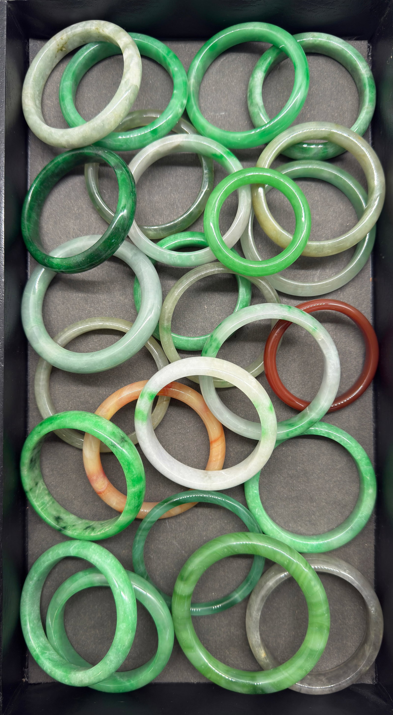 Large Lot of Chinese Bangle Bracelets.: Some are stone and some are glass. There are 25 pieces in all. All of them look to be in good condition. The largest bangle measures 3 1/4" in diameter, with a 2 1/2" diameter interior. In-house shipp