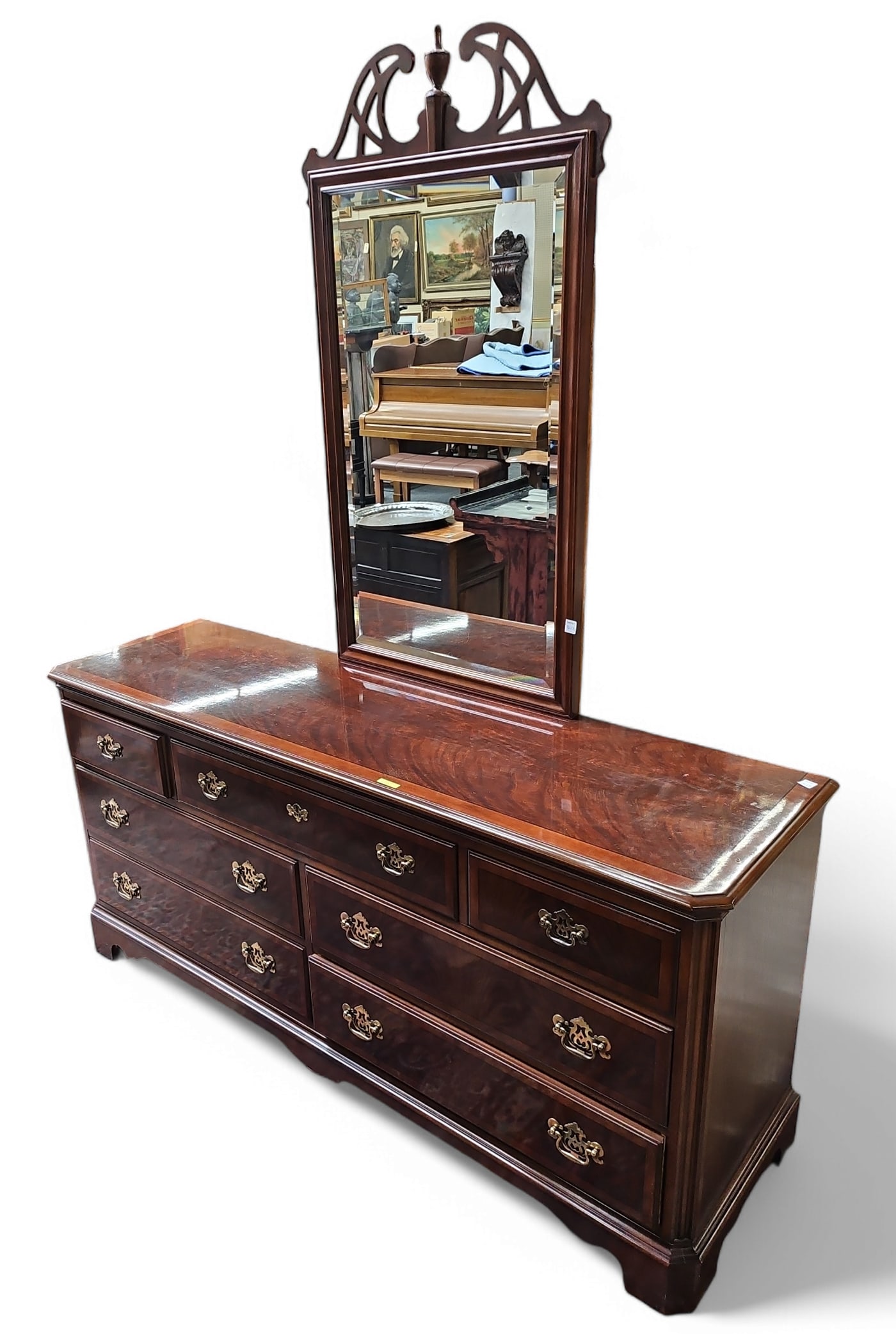 Drexel Heritage Flame Mahogany Dresser w/ Mirror.: This banded and inlaid mahogany dresser has a carved and bevelled glass mirror. It is in the chippendale style. The dresser has 7 drawers and brass hardware. It has a small indentation on the top, and