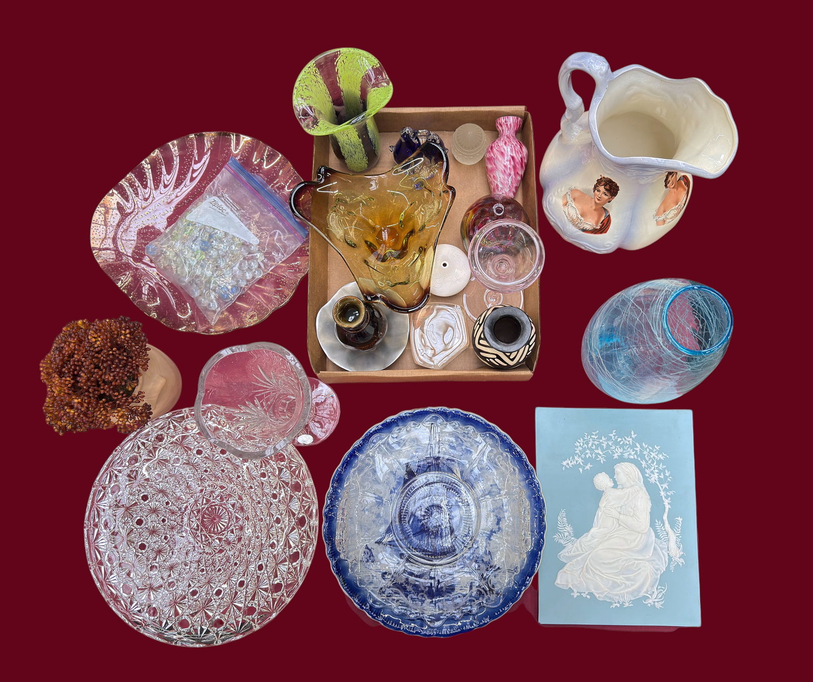 Lot of Various Art Glass, Crystal, & Ceramic Pcs.: The lot contains 21 items, and a small bag of mostly antique glass marbles. The lot includes vases, seed vases, a large pitcher, serving plates, paperweights, and a wedgwood style queensware plaque. T