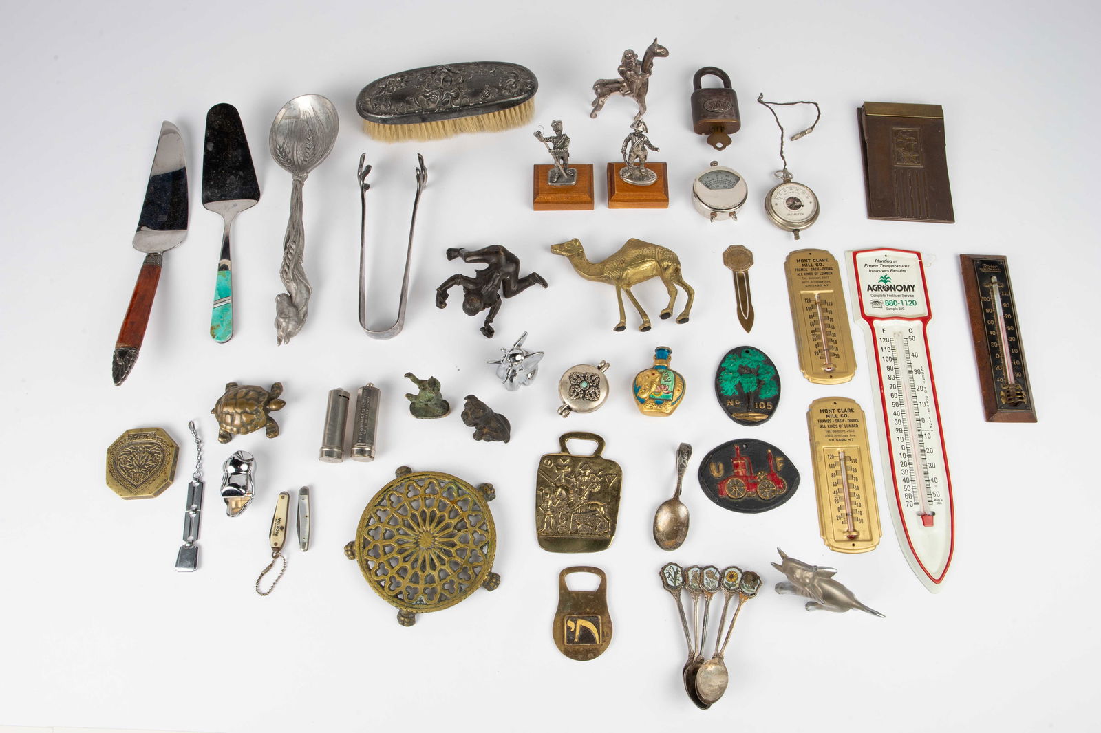 Lot: Soldier Figurines, Paperweights, etc.: This lot of mostly vintage items includes metal figurines of both animals and people, serving utensils, souvenir spoons, advertising thermometers, bottle openers, a silverplate brush, and more. Some i