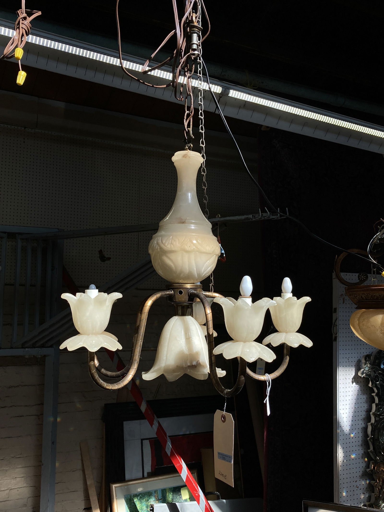 Carved Alabaster 5 Arm Chandelier w/Flowers: This 5 arm, 6 light chandelier features carved designs and floral shades. It measures 19" long and 22" in maximum diameter (not including the chain). There may be some stains on the piece. Otherwise,
