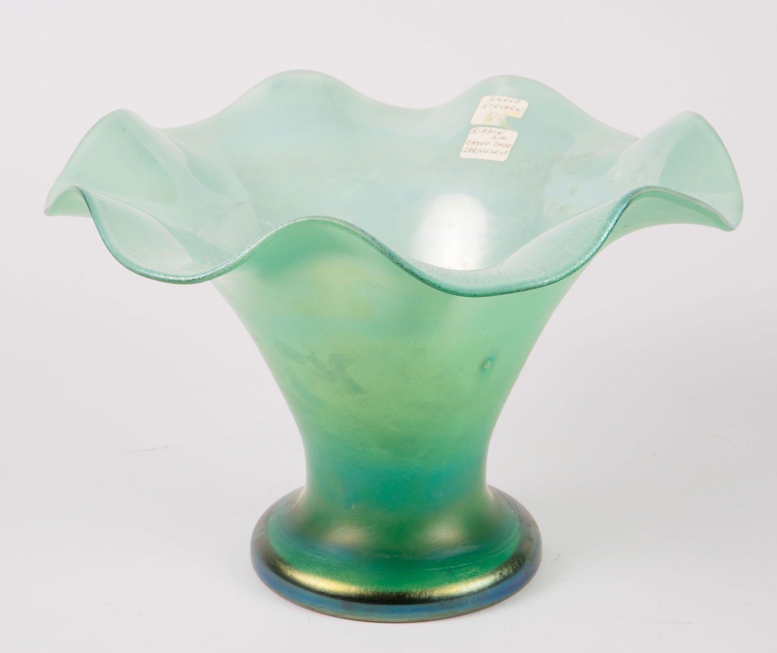 Steuben Iridescent Jade Crystal Ruffled Rim Bowl.: This antique centerpiece bowl is acid etched Steuben along with a fleur-de-lis on the underside of the piece, indicating its production date was between 1903-1933. The ruffled edged bowl has an interi