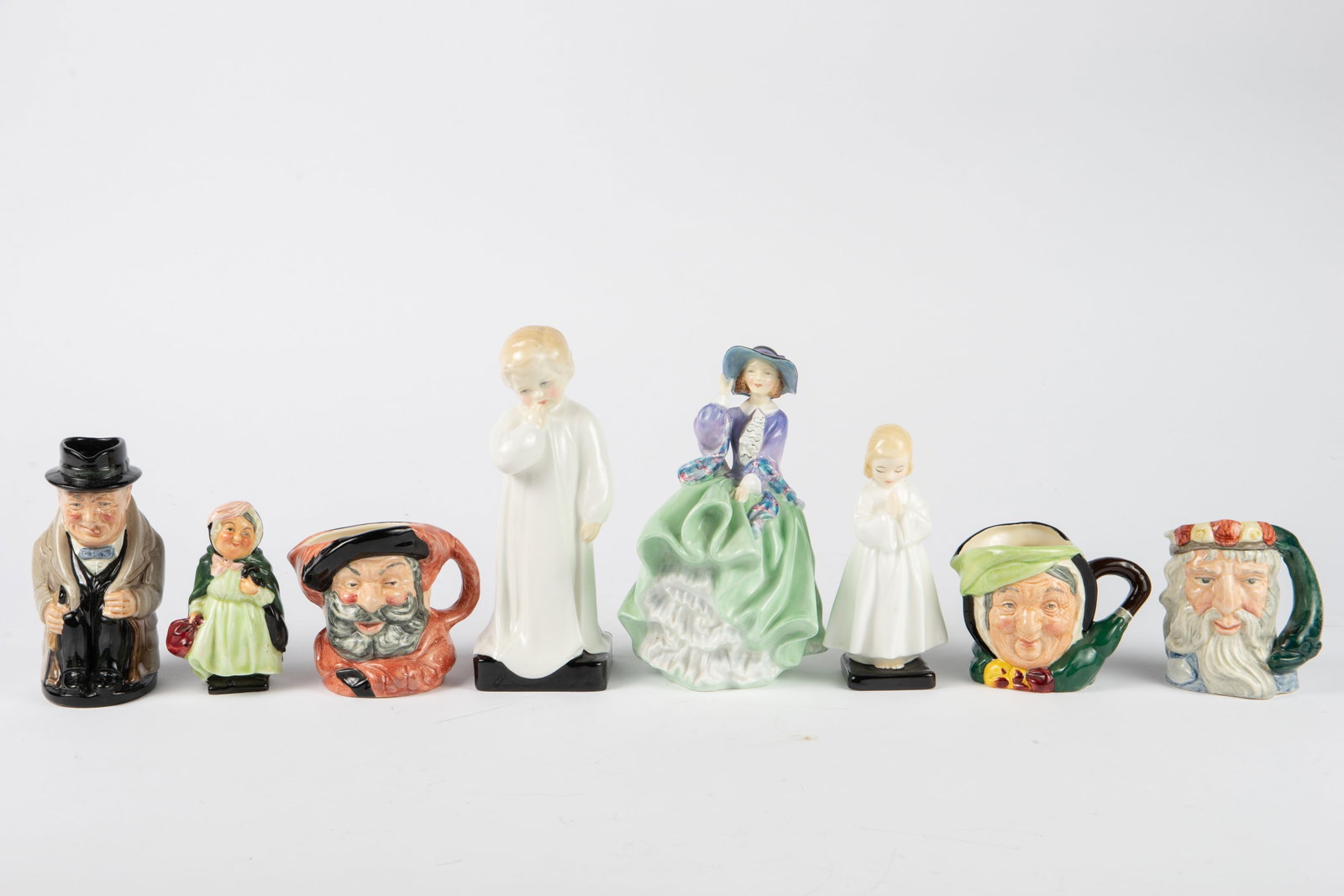 Lot of 8 Royal Doulton Figurines & Toby Mugs.: The lot contains 8 Royal Doulton bone china items, including 3 small Toby character mugs. The figures included are #822821 "Top o' the Hill", #1319 "Darling", #1978 "Bedtime", and "Sairey Gamp" which 