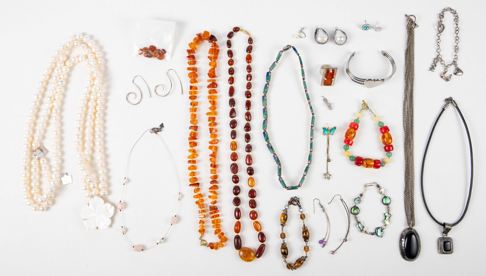 Sterling & Gemstone Jewelry - Gliwinski, Amber.: The lot contains 17 pieces of jewelry, and a few single earrings. Many of the pieces are sterling silver, or have sterling parts, including the DKNY charm bracelet, the multistrand necklace with a lar