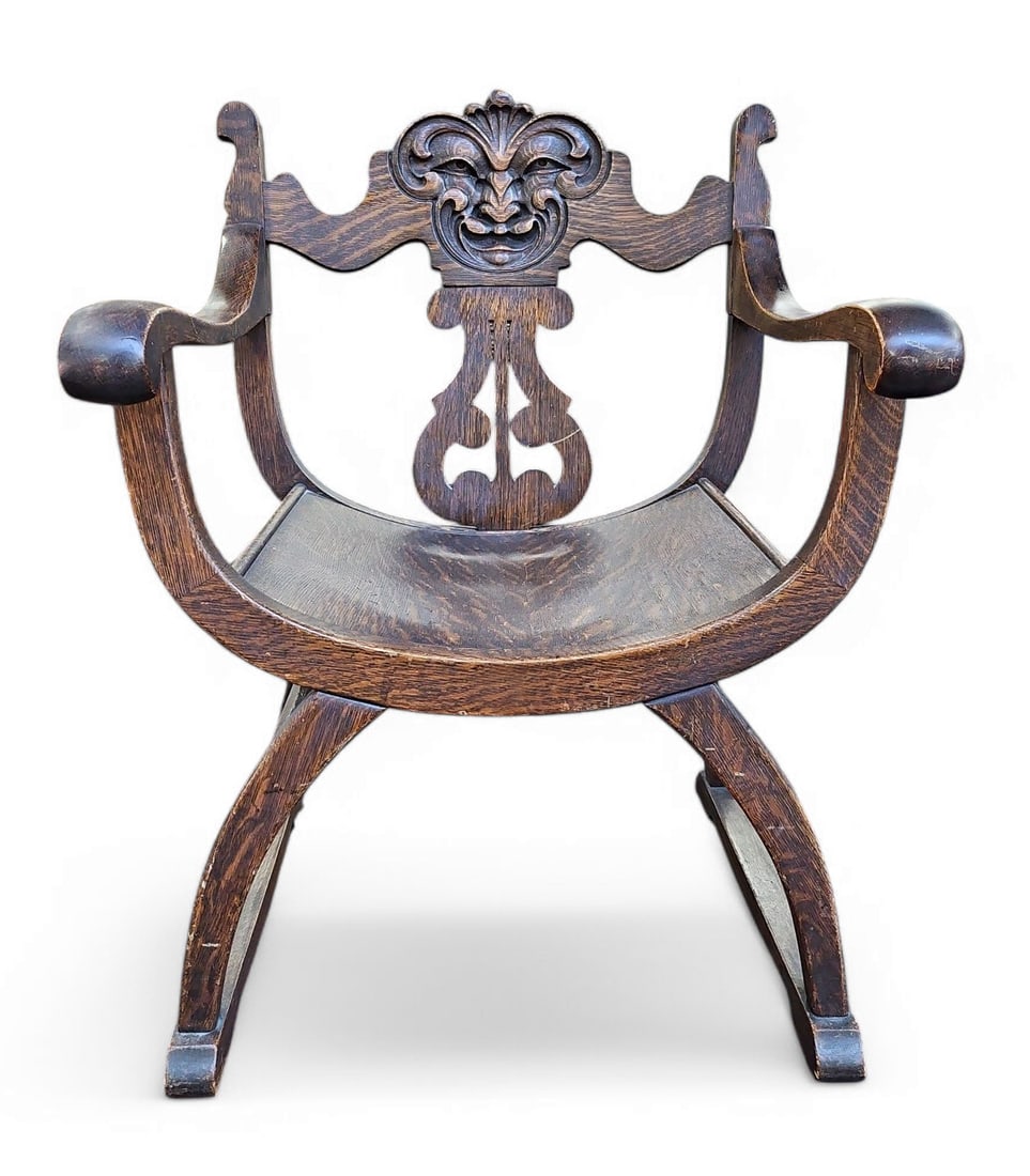 Oak Savonarola Style Chair w/ North Wind Face.: This oak chair was manufactured by Stomps-Burkhardt (No. 102) and features a carved North Wind face. It measures 33 1/2" tall, 23" wide, and 20 1/4" deep. There are some scratches and chips along the