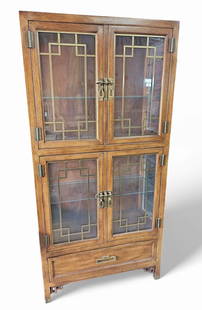 Century Furniture Asian Style Display Cabinet.: This lighted cabinet has two display compartments, each with double doors featuring brass fretwork and pulls. Below the display compartments is a large drawer. The piece is in good condition. The ligh