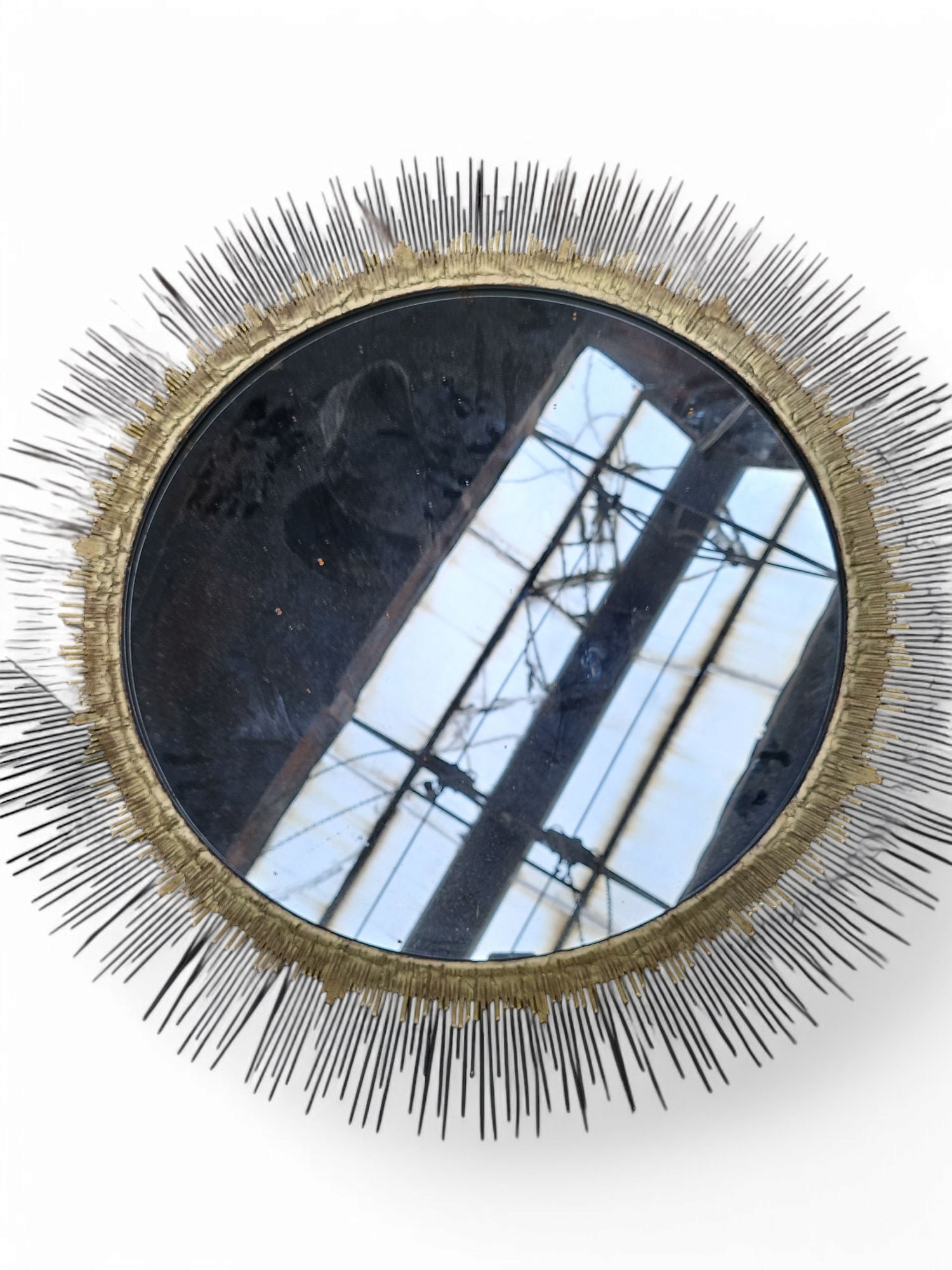 Crate & Barrel Round Starburst Mirror.: The mirror features a 5" irregular metal rod frame with gilt nearest to the mirror. It measures 32" in diameter (including the frame). There are some stains on the piece. Otherwise, it is in overall g