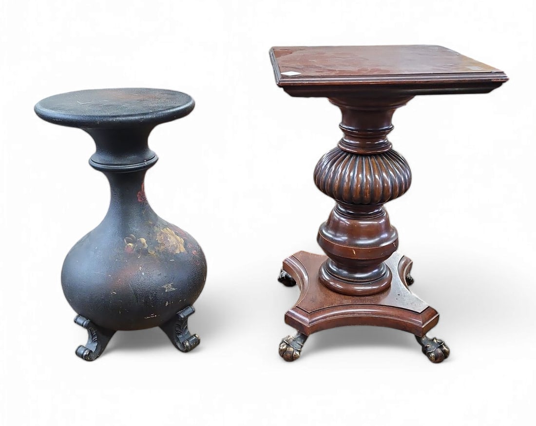 2 Antique or Vintage Pedestals.: The lot contains 2 pieces of furniture. First, there is a carved and turned wood piece with brass ball and claw feet and a square top. Next, there is a black leather lined piece with a round top, whic