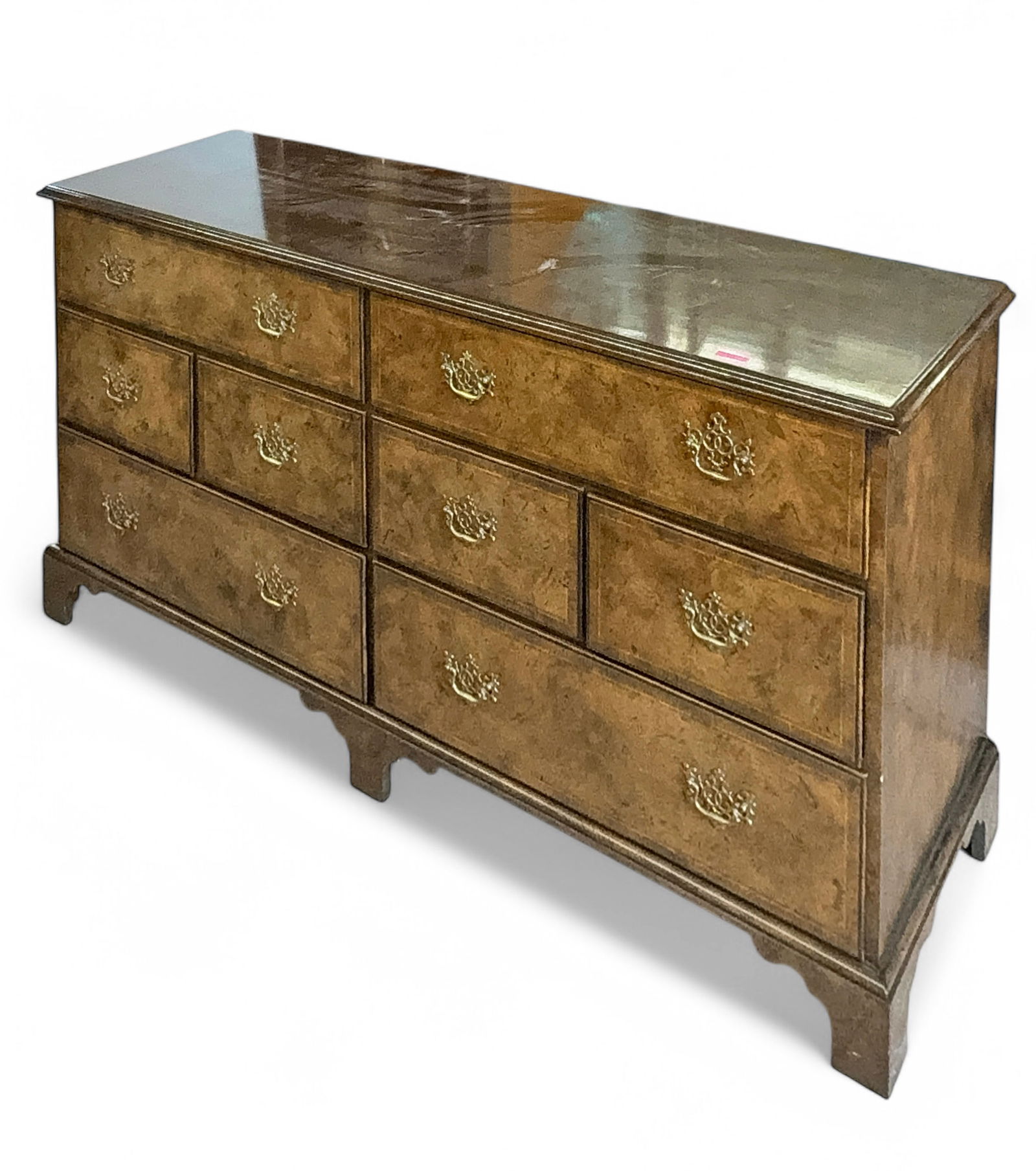 Baker Burled Wood Credenza or Dresser.: The eight drawer dresser has brass floral hardware. It measures 32" x 66" x 19". There are some small indentations on the top rear. Otherwise, it is in overall good condition. Third-party freight ship