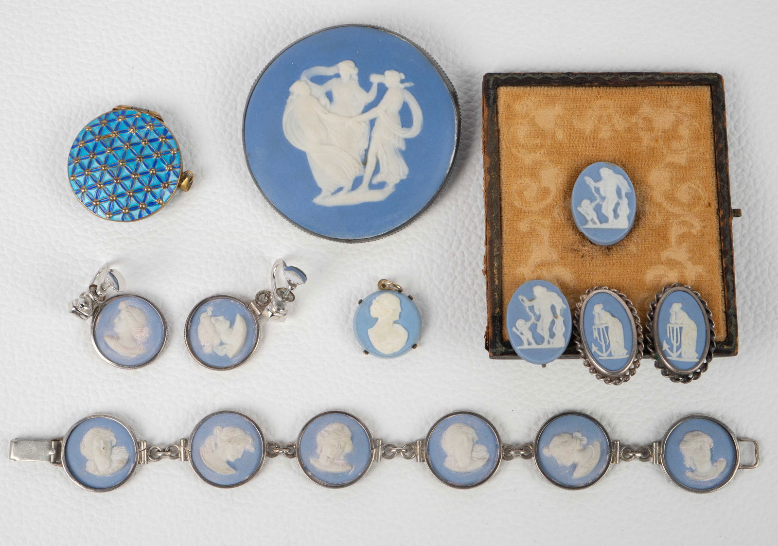 Lot of Mostly Wedgwood Jewelry.: The lot contains 7 pieces of jewelry, 6 of them Wedgwood. There is a bracelet, 3 pair of screw back earrings (one earring is set in a frame), a pendant, a brooch, and an unbranded enameled locket. The