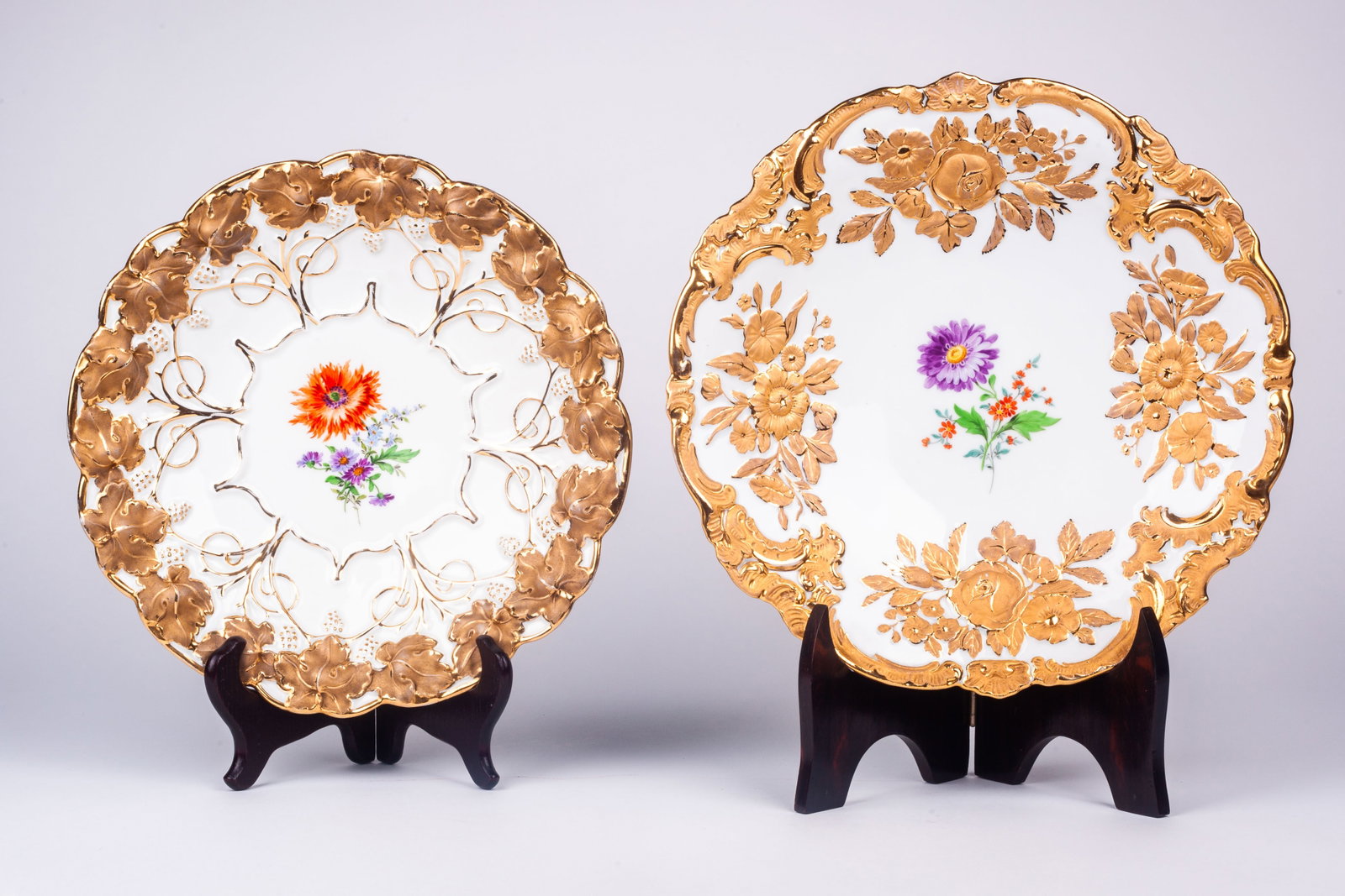 Lot of 2 Meissen Rococo Bowls w/ Flowers.: This lot consists of two shallow bowls with gilded flowers and leaves that surround central painted flowers. Aside from some minor gilt loss, they both look to be in nice condition. Each bowl bears th
