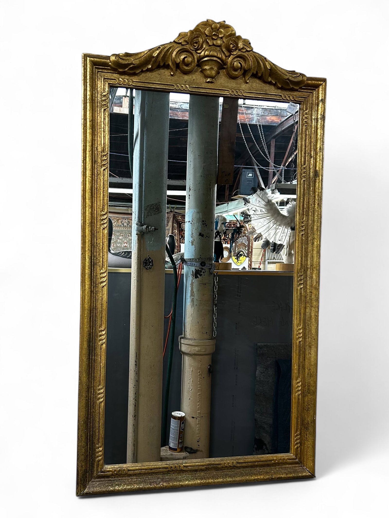 Carved Wall Mirror.: This gilt and carved wall mirror has a floral crest. Overall it is in good condition, with some wear and gilt loss. It measures 49" tall and 26" wide. Third-party freight shipping or personal pickup i
