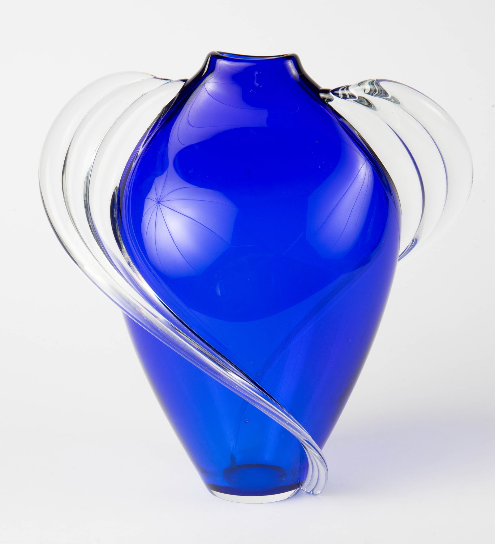 Thomas Buechner III Blue Art Glass Vase, "Vitrix": The vintage art glass vase is signed Thomas Buechner III / Vitrix / 10-18-1982 on the underside. It measures 9 1/4" x 8 3/4" x 5 1/4". There is a small chip at the base of one of the clear glass swirl