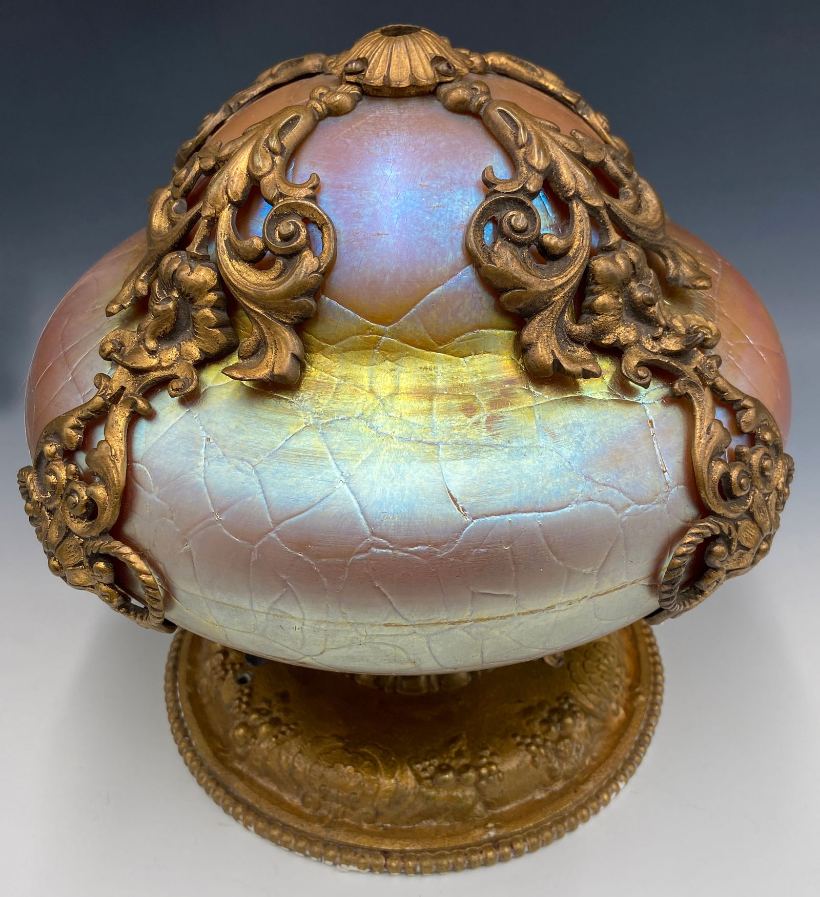 Steuben ? Iridescent Fixture w/ Gilt Bronze Mounts: This gold textured glass mushroom lamp shade is reminiscent of Tiffany Favrile or Steuben Aurene. It somewhat resembles an Oscar Bach fixture. The art glass is housed inside elaborate gilded bronze mo