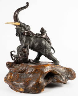 Lg Japanese Meiji Period Bronze Elephant w/ Tigers: The bronze is signed under the belly of the elephant. It is not attached to the natural wood stand. The bronze depicts two tigers attacking an elephant. There are some minor scratches, and the tusks h