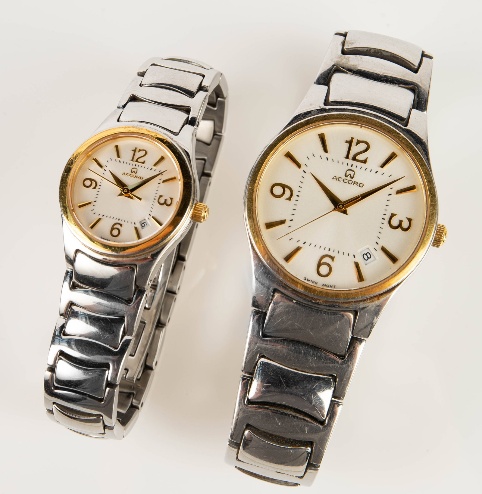 His and Hers Vintage Accord Wristwatches.: The lot contains 2 stainless steel silver tone Accord wristwatches with gold tone bezels in 2 different sizes. The ladies' watch is model 661432, and has a 25mm case. The ladies' watch is working fine