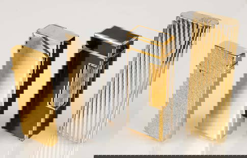 Lot of 4 Vintage Lighters - Dunhill, Colibri, Etc.: The lot contains 4 vintage lighters. There is a black and gold Dunhill, a silver toned Scripto, a brushed gold toned Scripto, and a ribbed gold toned Colibri. The smallest piece measures 2 1/4" x 7/8"