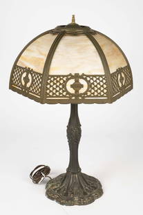 6 Panel Slag Glass Table Lamp w/ Bronzelike Base.: The maker is unknown. The base looks to be spelter with a bronzelike finish. There is some minor surface wear, but overall, the piece looks to be in good cosmetic condition. It measures 26" tall, with