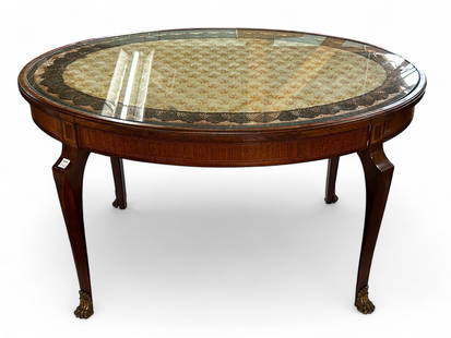 Carved French Table with Glass Top.: This satin and exotic wood coffee table has a removable glass insert, and beneath the glass is an embroidered lace portion attached to the wood. The legs have bronze paw feet. There are some scratches