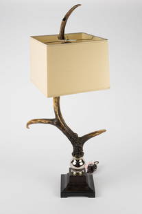 Large Faux Antler Table Lamp.: The lamp features a leather wrapped base with a metal spherical decoration on top, which holds the composition 3 point antler. One of the points is set as the lamp finial. It measures 39" x 17" x 13".