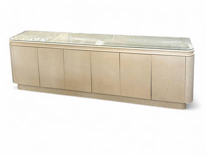 Glossy White Lacquered Buffet with Glass Top.: This buffet or sideboard has a protective glass top, and six lower doors with internal drawers and shelves. The sides are curved, and it sits on a platform style base. It is in good overall condition.