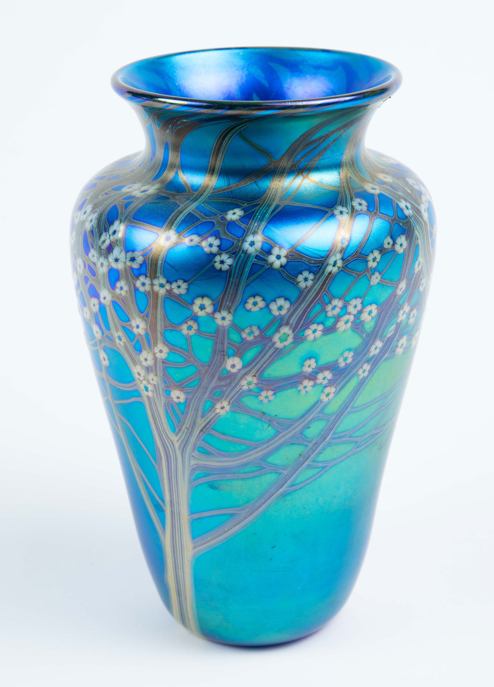 Orient & Flume Blue Hawthorn Glass Vase.: It is signed and numbered underneath. The vase is iridescent blue, decorated with flowering trees. It looks to be in very good condition, with a little residue on the inside from when stickers were at