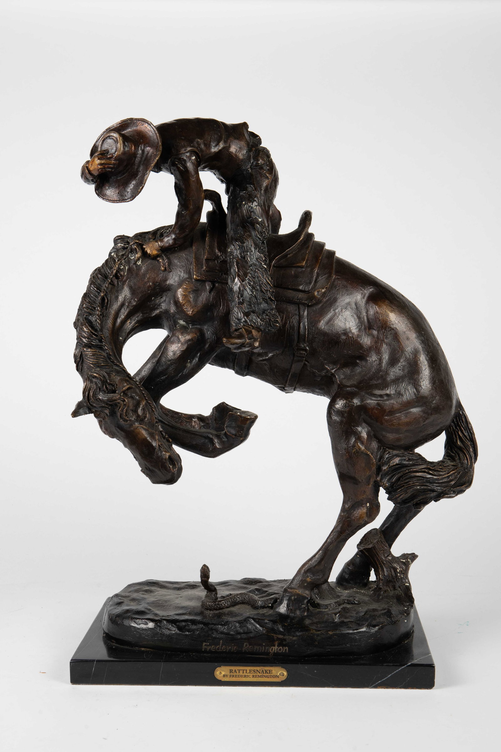 Bronze Sculpture After Remington, "Rattlesnake".: The sculpture depicts a man on horseback being spooked by a rattlesnake on the ground. It is signed Frederick Remington on the front side on the bronze base. The marble base has a brass plaque with th