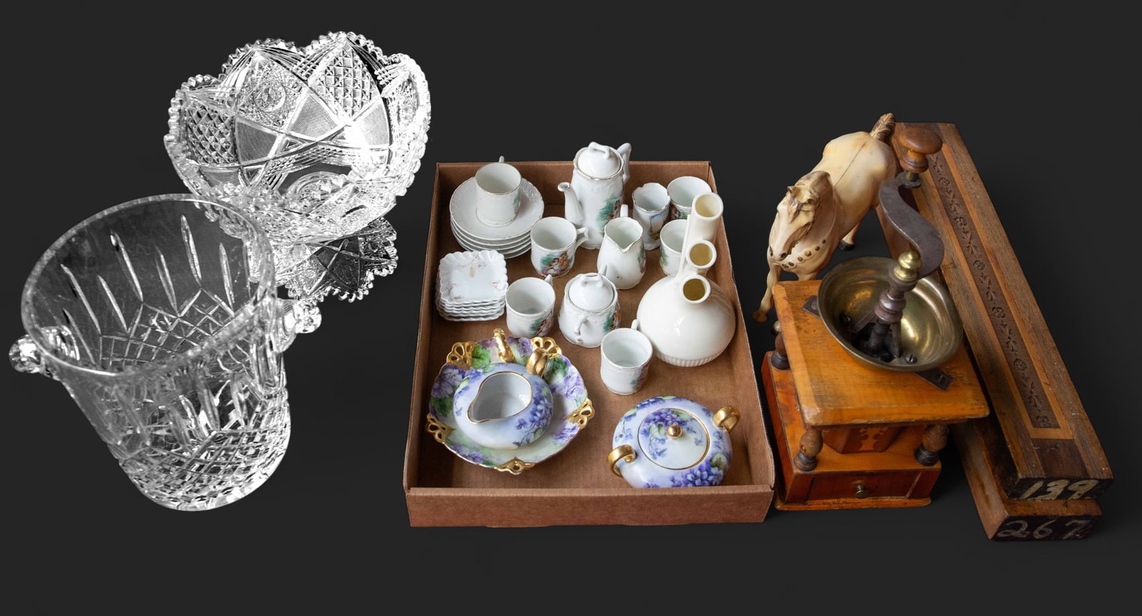 Lot: Coffee Grinder, Assorted Crystal & Porcelain.: This lot includes a brass and wood grinder, a child's German tea set, a Lenox "Aorta" vase, a crystal champagne bucket, a plastic horse figurine, and more. Overall, the lot looks to be in good conditi