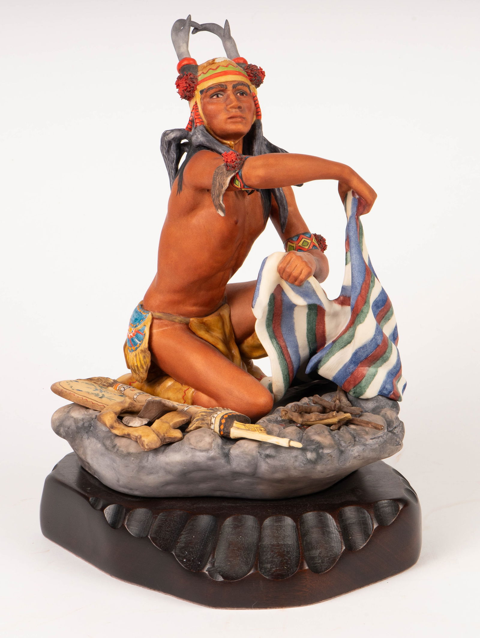 Cybis Apache Chato Porcelain Sculpture, Signed.: This limited edition sculpture is signed Cybis #104 on the back near the wooden base. It features a Native American Apache Chato Indian man putting out a fire. It measures 13" x 10" x 7 1/2". The piec