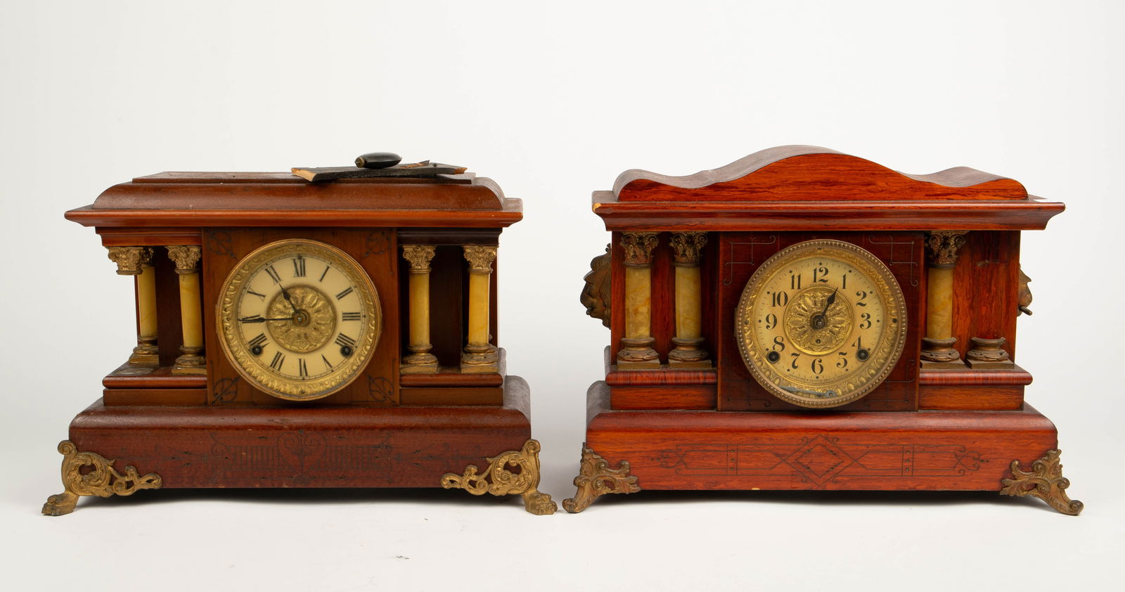Lot of 2 Seth Thomas Pillar Mantel Clocks.: The lot contains 2 similar keywind clocks by Seth Thomas. They feature etched designs on wood, decorative pillars and brass. The 6 pillar piece has paw feet, and the other piece has a brass mythologic